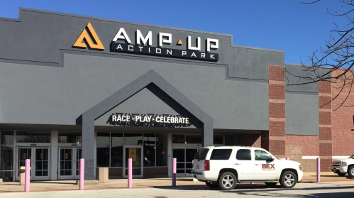 Exterior of Amp Up Action Park, featuring a large sign and a welcoming entrance.