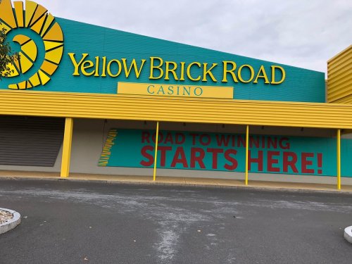 Exterior of the Yellow Brick Road Casino, featuring a colorful sign that reads "Road to Winning Starts Here!"