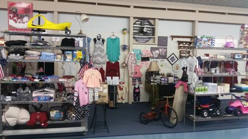A display of various items for sale, including clothing, toys, and household goods in a store setting.