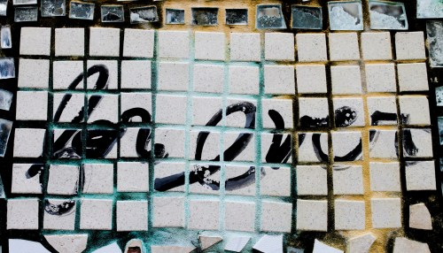 Mosaic artwork featuring the words "Mr. Over" in black on a background of light-colored tiles.
