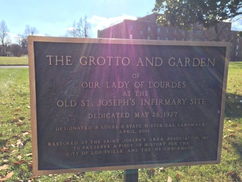 Bronze plaque detailing the Grotto and Garden of Our Lady of Lourdes at the Old St. Joseph's Infirmary site.