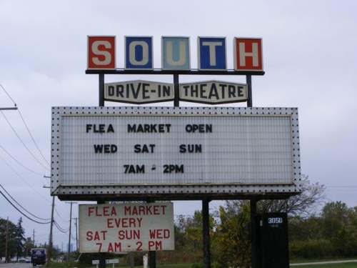 Sign for South Drive-In Theatre advertising flea market hours: Wed, Sat, Sun from 7 AM to 2 PM.