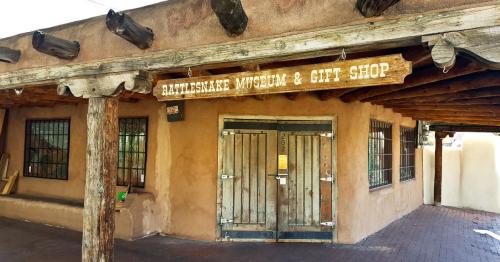 Exterior of the Rattlesnake Museum and Gift Shop, featuring a wooden sign and adobe-style architecture.