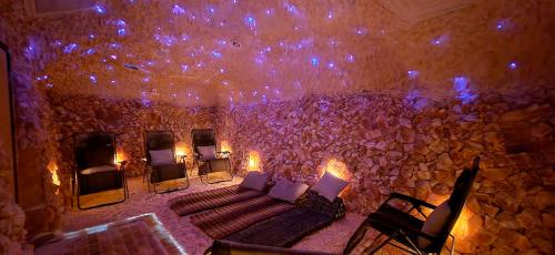 A tranquil salt room with stone walls, lounge chairs, and soft blue lighting, creating a calming atmosphere.