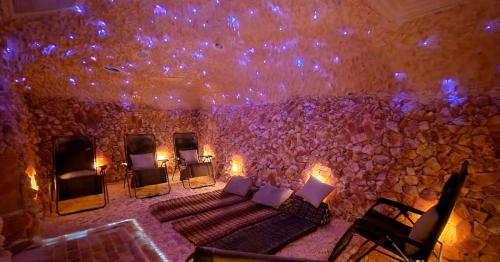 A tranquil salt room with stone walls, reclining chairs, and soft lighting, creating a serene atmosphere for relaxation.