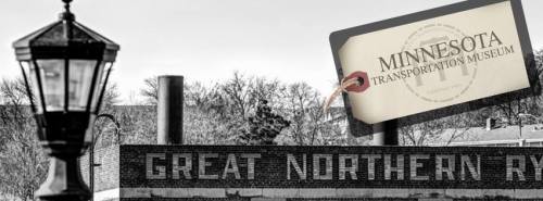 Black and white image featuring a street lamp and the sign for the Minnesota Transportation Museum.