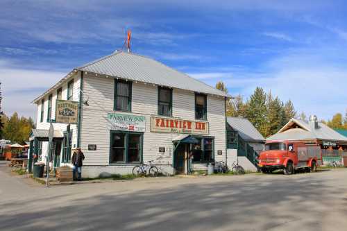 Historic Fairview Inn with a vintage truck parked outside, surrounded by trees and a clear blue sky.