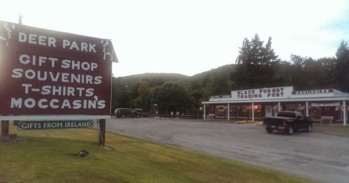 Sign for Deer Park with a gift shop and trading post in a scenic area, featuring souvenirs and moccasins.