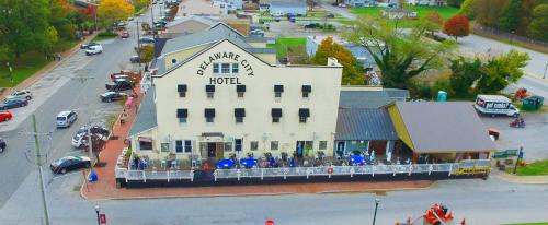 Aerial view of Delaware City Hotel, featuring outdoor seating and nearby buildings in a small town setting.