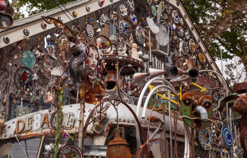 A whimsical display of metal sculptures and colorful decorations adorns a building's exterior.