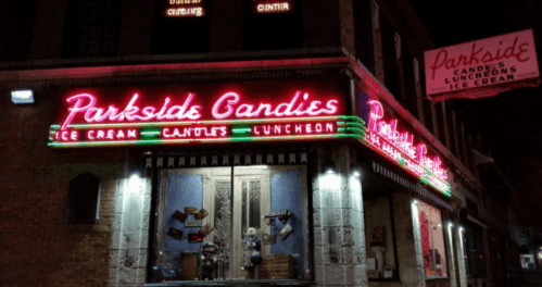 Neon sign for Parkside Candies, featuring ice cream and luncheon offerings, illuminated at night.