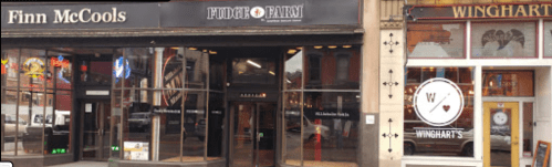 Exterior view of two restaurants, Finn McCools and Winghart's, with large glass windows and signage.