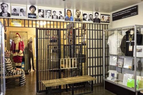 A museum exhibit featuring a jail cell, historical photos, and displays about crime and punishment.