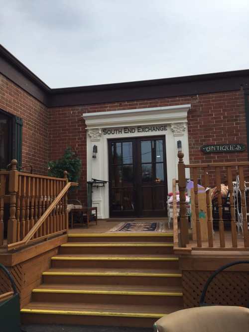 Entrance of South End Exchange with wooden steps and a decorative sign above the door.