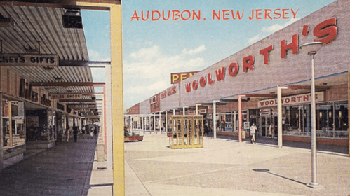 A vintage postcard view of a shopping plaza in Audubon, New Jersey, featuring Woolworth's and various storefronts.