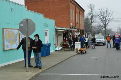 A small town street scene with people walking, shops decorated for the holidays, and a map on a wall.