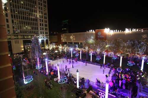 A vibrant outdoor ice skating rink surrounded by festive lights and a crowd enjoying the winter evening.