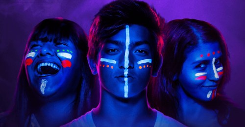 Three young people with vibrant face paint, set against a colorful, dramatic background, expressing different emotions.