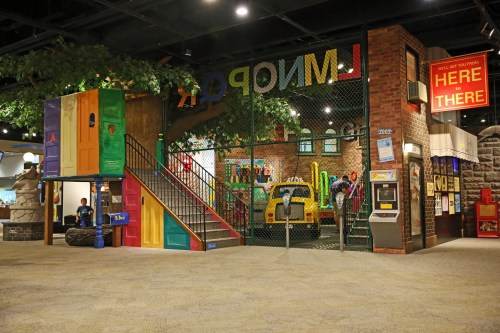Colorful indoor play area with a tree, stairs, and various interactive features for children.