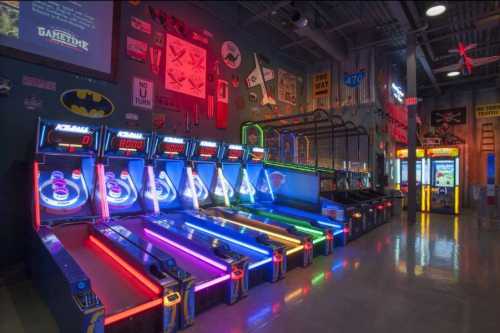 A vibrant arcade with neon-lit skee-ball machines and various games lining the walls.