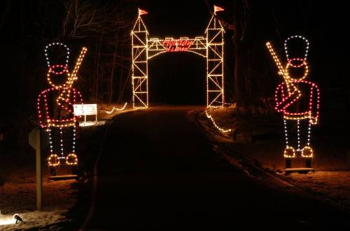 A festive entrance decorated with lights, featuring two toy soldier figures on either side of a lit archway.