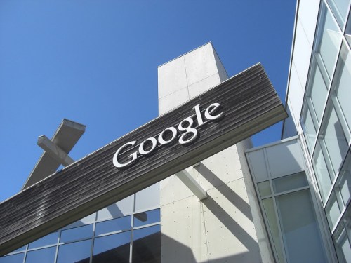 Signage of the Google building against a clear blue sky, showcasing modern architecture.