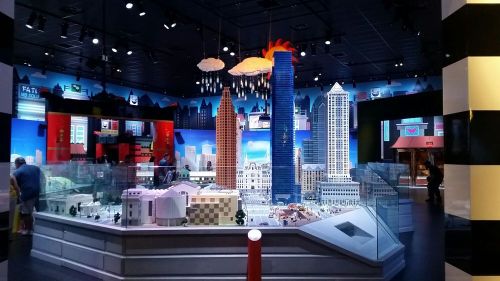 A vibrant display of a cityscape made from LEGO bricks, featuring various buildings and colorful decorations.