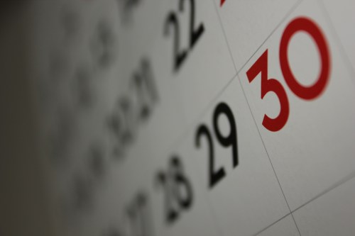 Close-up of a calendar page highlighting the number 30 in red, with surrounding dates in black.