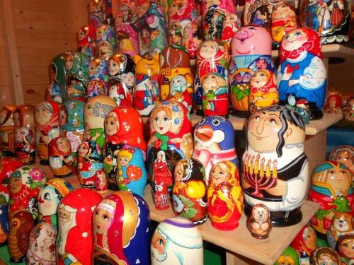 A colorful display of various Russian nesting dolls, featuring intricate designs and characters in vibrant colors.