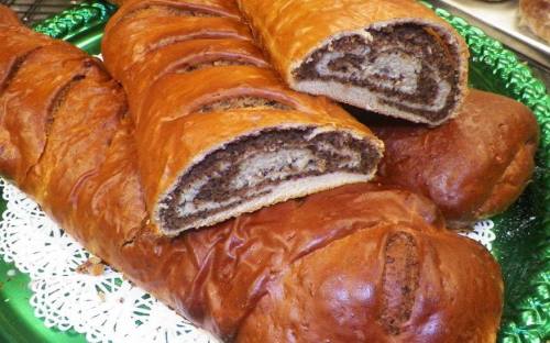 A close-up of sliced sweet bread with a rich nut and chocolate filling, displayed on a decorative plate.