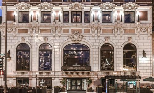 Elegant historic building with ornate architecture, large windows, and decorative details, illuminated at night.