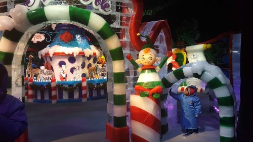 Colorful ice sculptures of candy canes and whimsical characters in a festive winter scene.