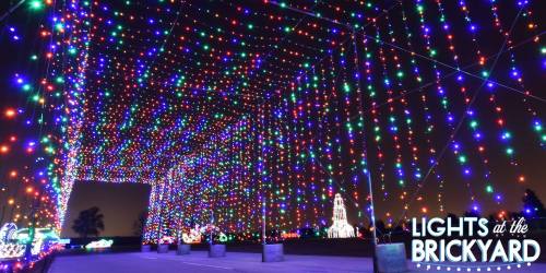 A vibrant display of colorful lights hanging in a night sky, creating a festive atmosphere at the Brickyard.