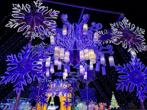 A vibrant display of blue and white holiday lights shaped like snowflakes and lanterns, creating a festive atmosphere.