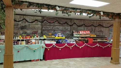A decorated food display with various snacks, condiments, and festive garlands in a cozy indoor setting.