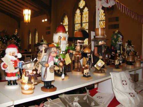 A display of various decorative nutcracker figurines in a festive setting, with holiday decorations in the background.