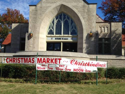 A building with a large banner advertising a Christmas market on December 2 and 3, with specific hours listed.