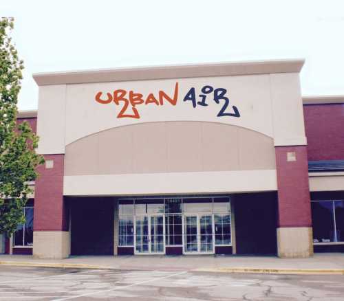 Exterior of an Urban Air facility with a large sign, featuring colorful lettering on a brick building.