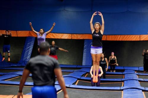 A group of people jumping on trampolines in a vibrant indoor trampoline park.