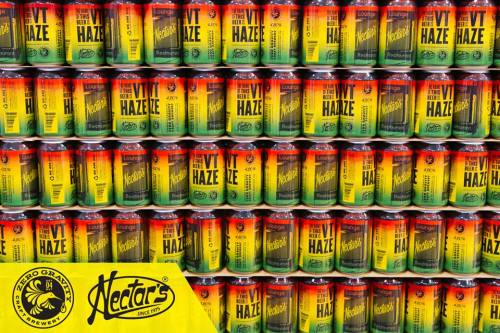 A colorful display of stacked beer cans labeled "VT Haze" with a yellow logo for Nectars Brewery.