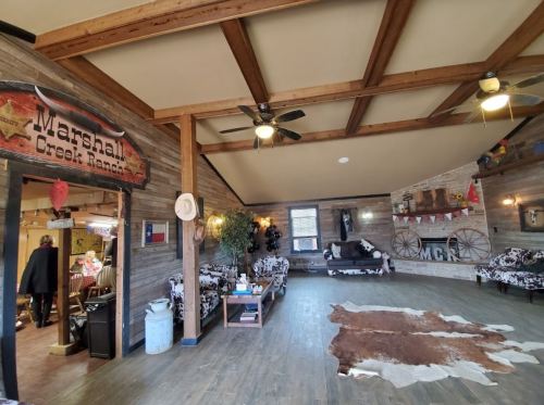 Cozy interior of Marshall Creek Ranch with wooden beams, rustic decor, and cowhide accents.