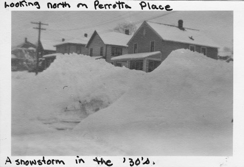 Black and white photo of houses covered in snow, with large snowdrifts, labeled "A snowstorm in the '30s."