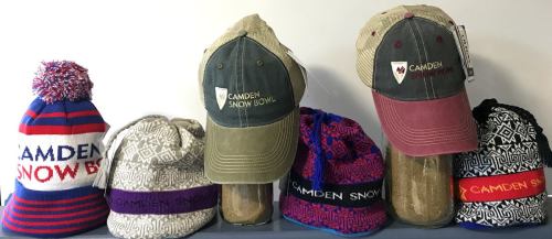 A variety of hats displayed, including beanies and baseball caps, all featuring the "Camden Snow Bowl" logo.