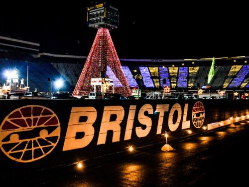 A brightly lit Christmas tree stands in a stadium at night, with "BRISTOL" prominently displayed in the foreground.
