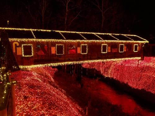 A beautifully lit bridge adorned with colorful lights, surrounded by a glowing landscape of festive decorations.