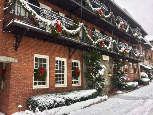 A brick building decorated with garlands and wreaths, covered in snow, creating a festive winter scene.