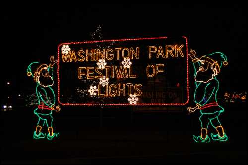 Colorful holiday lights display featuring a sign that reads "Washington Park Festival of Lights" with festive elves.