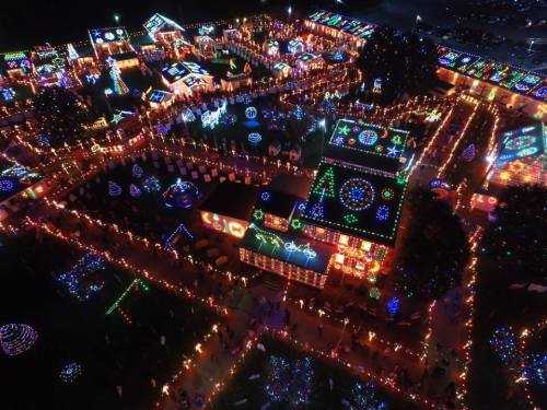 Aerial view of a festive display with colorful holiday lights illuminating a large area, creating a vibrant atmosphere.