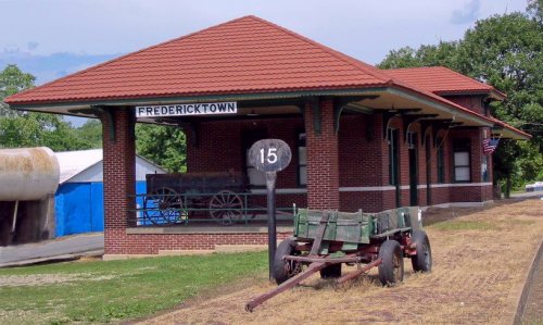 Historic brick train station in Fredericktown, featuring a wagon and a sign marked "15" in front.