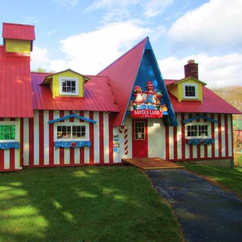 A colorful, striped building with a red roof and festive decorations, resembling a whimsical Santa's workshop.